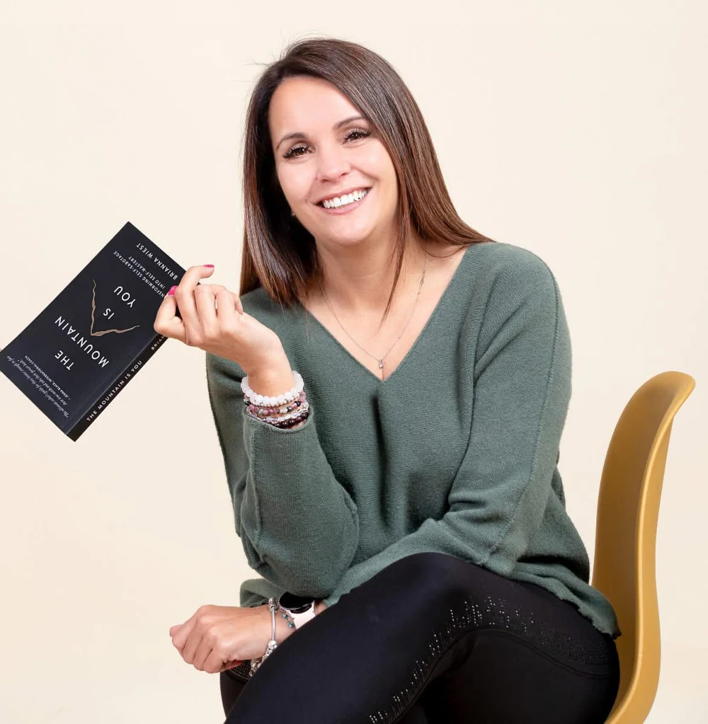Carla Smith smiling and holding a book
